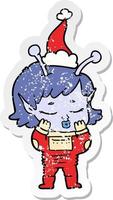 distressed sticker cartoon of a alien girl wearing santa hat vector