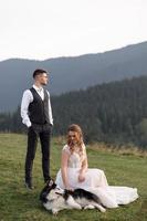 happy stylish bride and groom running and having fun in mountains on summer sunny day photo