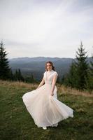 happy stylish bride and groom running and having fun in mountains on summer sunny day photo