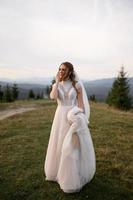 happy stylish bride and groom running and having fun in mountains on summer sunny day photo