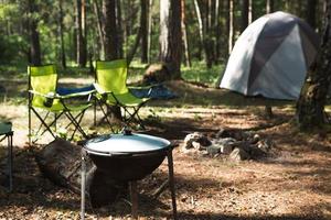 cocinar en un campamento en un fuego abierto en un caldero. picnic al aire libre, vacaciones de verano, accesorios de viaje foto