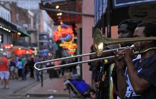 12 April 2017 - New Orleans, Louisiana - Jazz musicians performing in the French Quarter of New Orleans, Louisiana, with crowds and neon lights in the background. photo