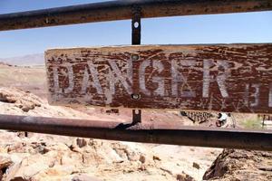 señal de peligro en un pueblo fantasma en el valle de la muerte, california foto