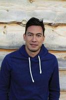 Young man with hoodie in front of wood background photo