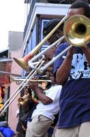 12 de abril de 2017 - nueva orleans, luisiana - músicos de jazz actuando en el barrio francés de nueva orleans, luisiana, con multitudes y luces de neón en el fondo. foto