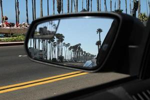 conduciendo a lo largo de la costa en santa barbara, california - palmeras reflejadas en el espejo del auto foto