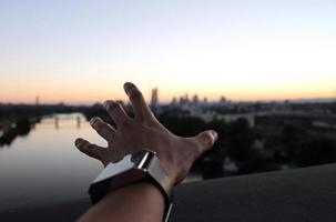 Hand reaching out to the horizon during dusk photo
