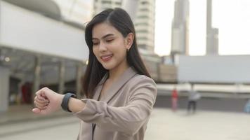 la mujer de negocios está usando un reloj inteligente en una ciudad moderna, tecnología de negocios, concepto de estilo de vida de la ciudad foto