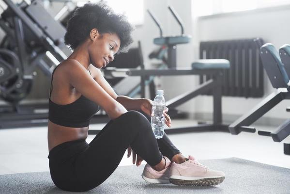 descanso después del entrenamiento. mujer afroamericana con cabello rizado  y ropa deportiva tiene un día de fitness en el gimnasio 15196285 Foto de  stock en Vecteezy