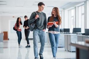 Not bad, I'm impressed by your work. Group of young people walking in the office at their break time photo