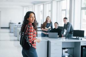 no te vi allí. grupo de jóvenes con ropa informal trabajando en la oficina moderna foto