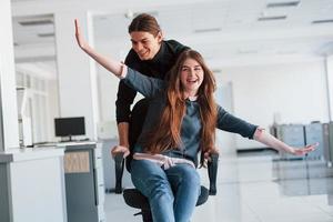 Imagine that you are the plane. Having fun in the office. Young people have a break and driving by using a seat photo