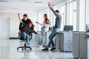 Having fun in the office. Young people have a break and driving by using a seat photo