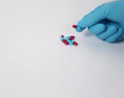 Taking or holding medication pills in hand. Capsule pill on white background. photo