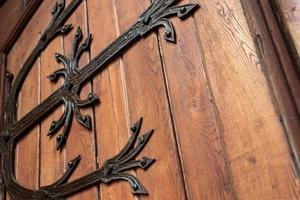 patrón de puerta forjada, decorativa. antigua entrada vintage, enorme puerta de madera pesada de iglesia o catedral. foto