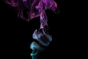 Multicolored smoke for aromatherapy relaxation on black background, beautiful swirled puffs of smoke photo