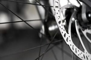 Bicycle disk brakes close up, metal disc attached to bike wheel, effective mountain bicycle brakes photo