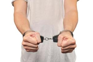 Hands of criminal in handcuffs, arrest of dangerous criminal, violation of law, white background photo