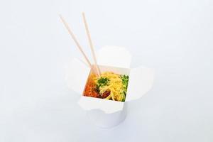 Rice wok in box and wooden chopsticks isolated on white background, Asian food delivery, close up photo