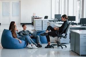 Please hear me out. Group of young people in casual clothes working in the modern office photo
