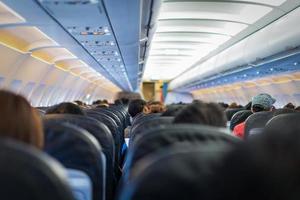 seats in the airplane and passenger sitting all area waiting for the plane taking off from runway. photo