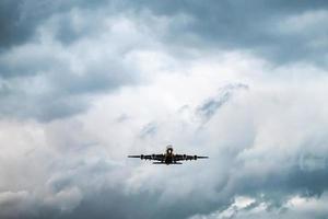 el avión despega del aeropuerto en la noche con cielo nublado oscuro. foto