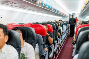 seats in the airplane and passenger sitting all area waiting for the plane taking off from runway. photo