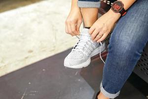 Asian woman is wearing and testing the sneaker in shoe store before to buy it photo