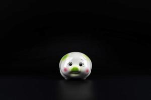 Isolated sad piggy bank on the black background with copy space. photo