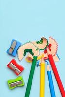 Top view of colored pencils, pencil sharpener and pencil shavings with space for text. Back to school concept photo