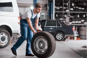 Going forward. Employee in the blue colored uniform works in the automobile salon photo