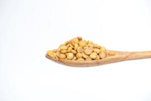 Soybean grain in the wooden spoon isolated on a white background. photo