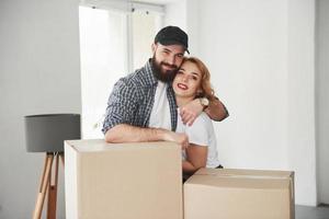 Embracing each other. Happy couple together in their new house. Conception of moving photo