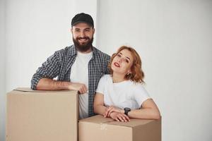 Leaning on boxes. Happy couple together in their new house. Conception of moving photo