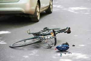 conducir ebrio. bicicleta y accidente automovilístico de color plateado en la carretera en el bosque durante el día foto