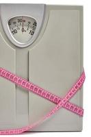 Scales with measuring tape, symbol and concept weight loss, sports and fitness. photo