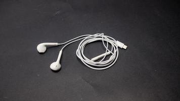 White headphones with plug isolated on black background photo