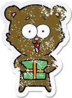 distressed sticker of a laughing teddy  bear with christmas present vector