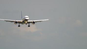 el avión comercial vuela, desciende para aterrizar, vista frontal. avión de pasajeros irreconocible en el cielo video