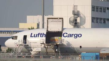 FRANKFURT AM MAIN, GERMANY   JULY 18, 2017 - Lufthansa Cargo McDonnell Douglas MD 11 airfreighter being loaded on the apron of Fraport cargo terminal. video