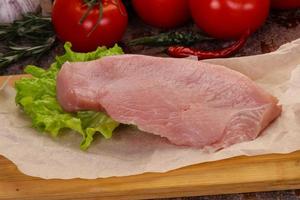 Raw Turkey steak served rosemary photo