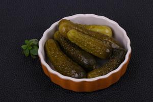 Pickled cucumbers heap in the bowl photo