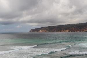 las olas peleando sobre la costa rocosa desierta del océano atlántico, portugal foto