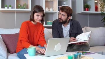 travail d'équipe à la maison. personnel travaillant à domicile. ils opèrent à partir de l'ordinateur en fonction des notes qu'ils ont entre les mains. video