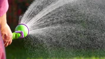 Woman watering the lawn manual garden sprinkler