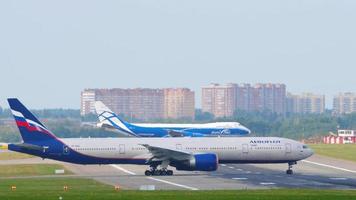 moscú, federación rusa 12 de septiembre de 2020 - aeroflot russian airlines boeing 777 airliner turn runway for take off while air bridge cargo boeing 747 airfreighter sale de la pista después del aterrizaje. video