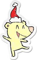 laughing bear distressed sticker cartoon of a wearing santa hat vector