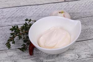 Mayonnaise sauce in the white bowl served thyme and garlic photo