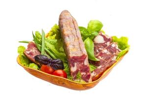 Ripe salami with salad, basil, onion and tomato photo