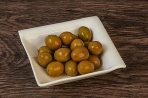 Green pickled olives in the bowl photo